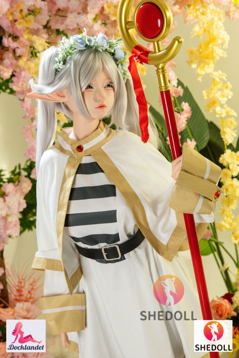 Frieren är en premium cosplay-docka inspirerad av den populära karaktären från Frieren: Beyond Journey’s End. Denna 155 cm långa silikon-modellen från SHEDOLL kombinerar en slank, alvlik estetik med fyllig G-kupa, realistisk hudkänsla och ett modernt EVO-skelett för naturliga poser. Karaktären Frieren är en 1000 år gammal alv-magiker och demon-jägare, även kallad "Frieren the Slayer", som med sin charmiga socialt inkompetenta stil vunnit många anime-fans hjärta. Detta är en enormt populär karaktär som nu än